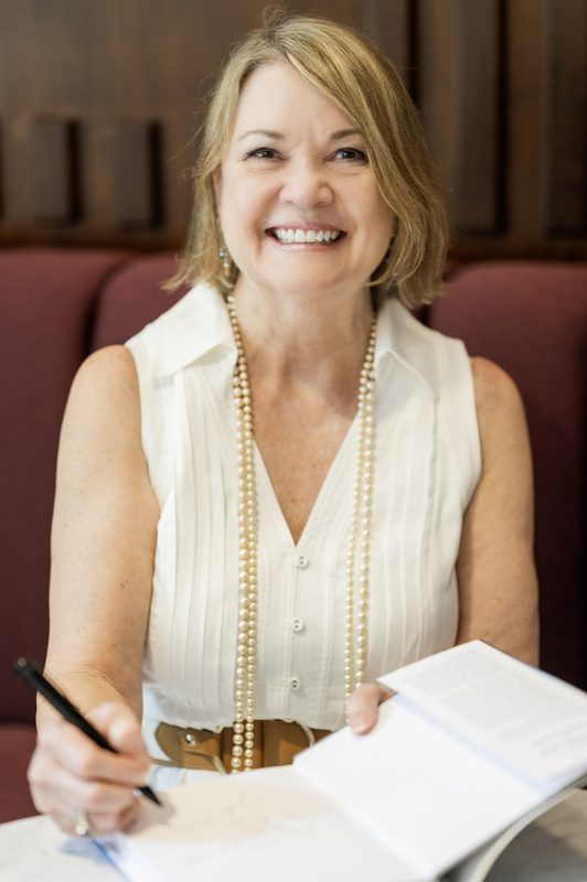 Cynthia Currence signing a copy of her book