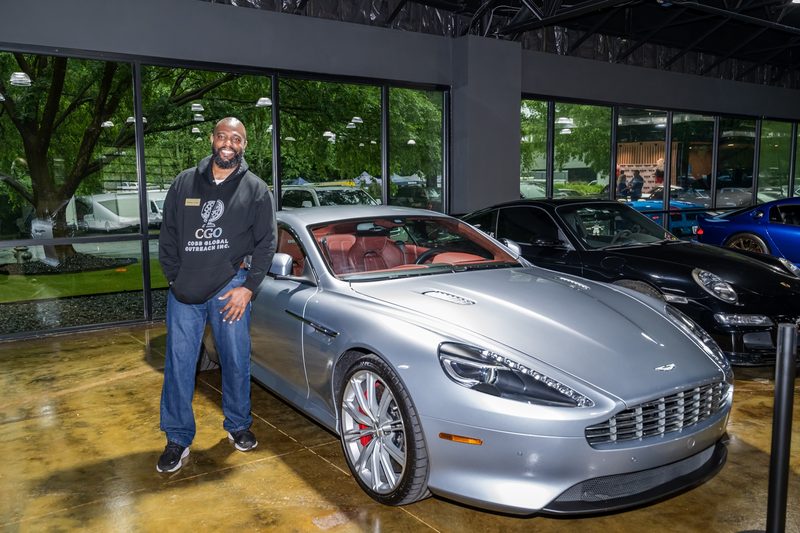 Bobby Cobb beside an Aston Martin at The Ride Lounge grand opening